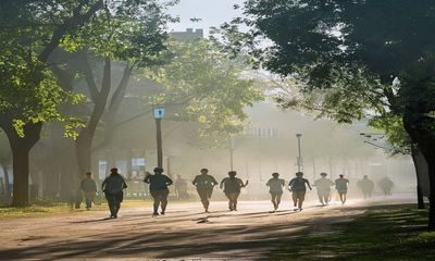 清晨校园操场晨跑的学生，薄雾中身影矫健，清新的校园早晨氛围，日在校园清晨场景记录
